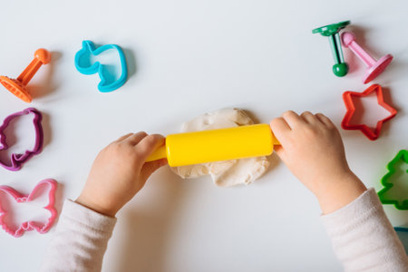 Close view of child's hands playing with homemade playdough. Children's creative game for early development and fine motor skills.の写真素材