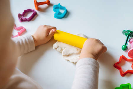 Close view of child's hands playing with homemade playdough. Children's creative game for early development and fine motor skills.の写真素材