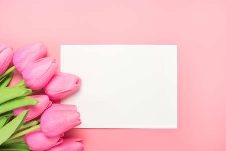 Spring flowers bunch of pink tulips on the pink background with plank greeting card. Mother's day or women's day composition.の写真素材