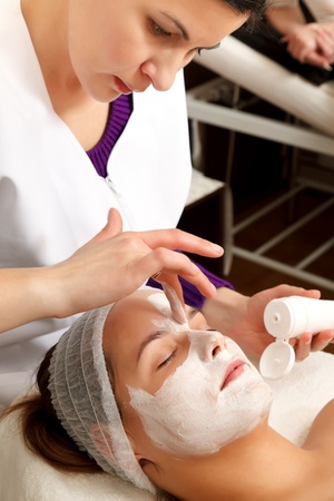 Young woman with a facial mask in a beauty salonの写真素材