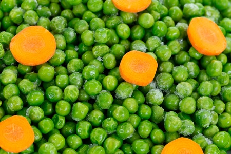 Closeup of frozen green peas with carrotsの写真素材