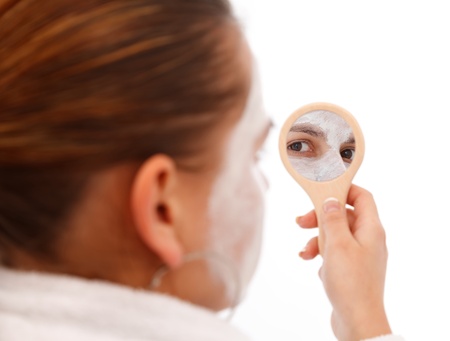 Young woman looking at the beauty mirrorの写真素材