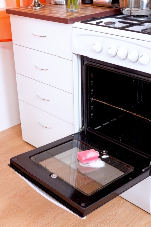 Opened dirty oven with a sponge and cleaning foamの写真素材