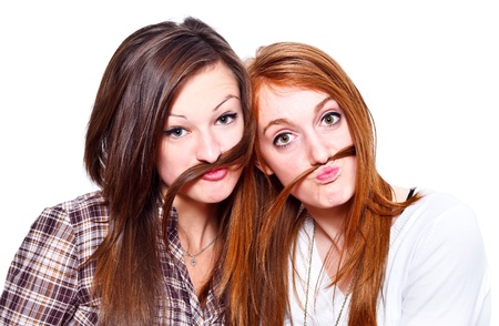 Two funny girls making moustache of their hairの写真素材