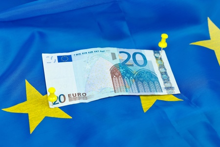 Euro beeing pinned down to an EU flag
の写真素材