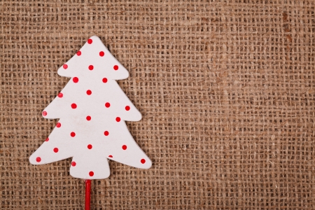Little white Christmas tree with red spots on burlap background
の写真素材