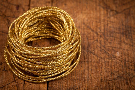 Golden rope batch on aged wooden table, Christmas concept
の写真素材