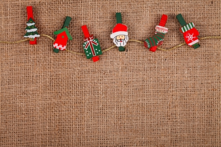 Little funny Christmas ornaments on golden thread, burlap background
の写真素材
