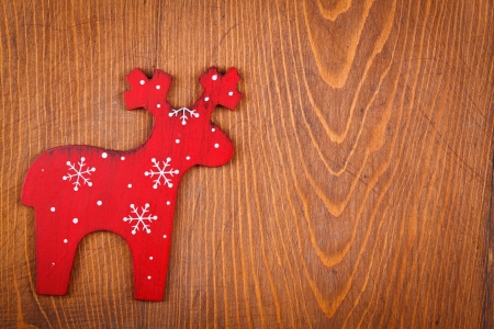 Red raindeer with white snowflakes on wooden background, ornament
の写真素材