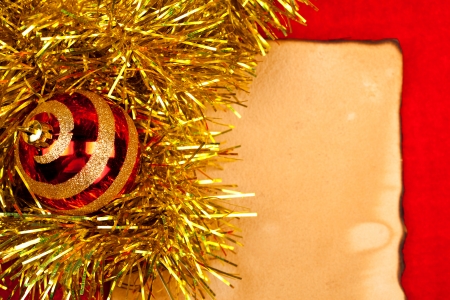 Christmas ornament on golden tinsel over burnt old style paper
の写真素材