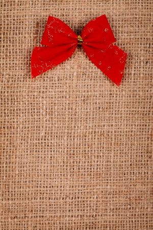 Little red ribbon on a burlap background, Christmas concept
の写真素材