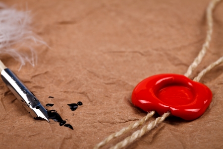 Old pen with red wax seal stamp on old paper
の写真素材