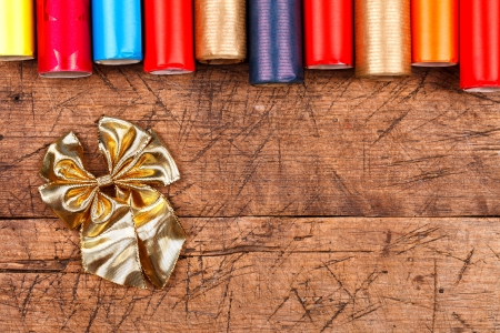 Little golden bow with colorful paper wrapping rolls on wooden 
の写真素材