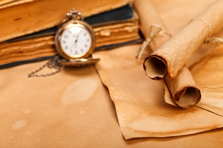 Old paper rolls in foreground, vintage pocket watch and books on blurred .
の写真素材