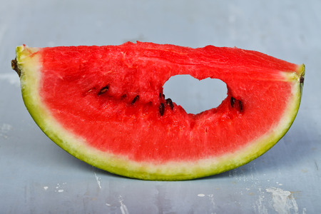 Slice of watermelon with symbol of heart cut into itの写真素材