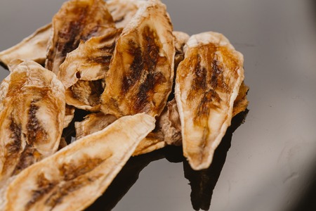 Dried fresh banana on a dark background.の写真素材