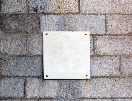 the marble plate beaten on a stone wallの写真素材