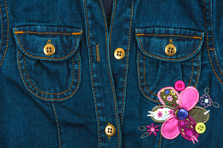 Jeans jacket with pockets and application of a flowerの写真素材