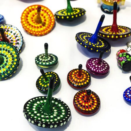 Wooden spinning tops of different sizes and colors. Image of jewish holiday Hanukkah with wooden...