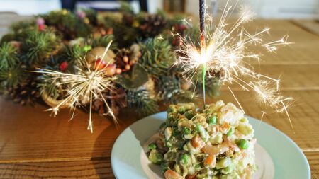 Christmas vein and holiday salad Olivier with burning sparklers. Christmas and celebrate concept.の写真素材