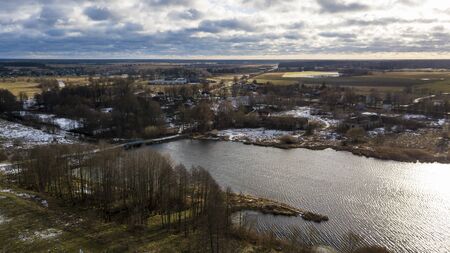Beautiful winter lake on cloudy sky background. Aerial view.