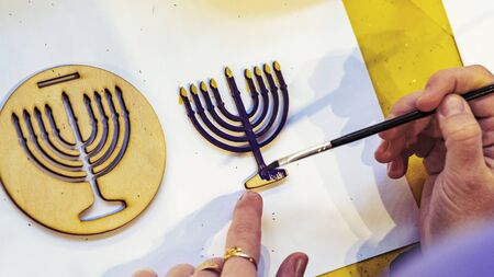 Coloring wooden menorah patterns for children on white background. Close-up. Hanukkah concept and...
