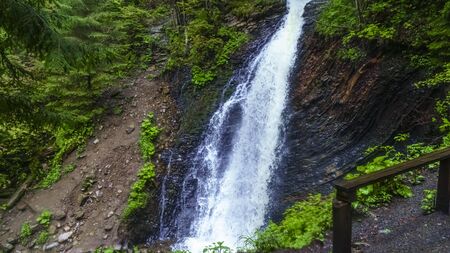Guk Falls breaks through rocks in Carpathians mountains. Travel concept.