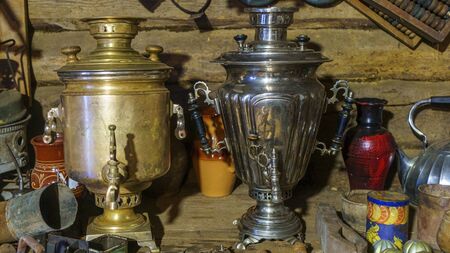 Two russian samovars on the background of rustic trash. Concept for garage sale.