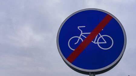 Traffic sign. Ends of zone for ride a bicycle. Background of dramatic sky.の写真素材