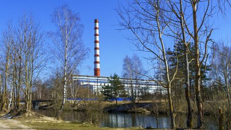 Chimney of thermal power station and water channel on classic blue sky background. Green power and...