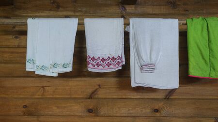Traditional slavic clothes and linen with ornaments are dried in a wooden house. Space for text.