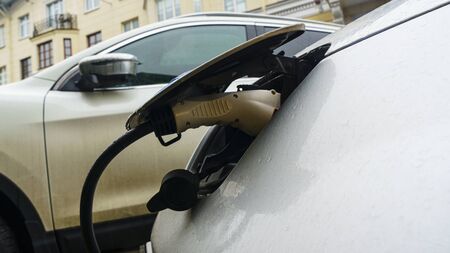 E-mobility: plug-in hybrid car at a charging station. Ecological and recharging concept.
