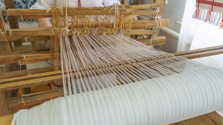 Vintage wooden parts of the loom with woven cloth. Handmade concept. Space for text.