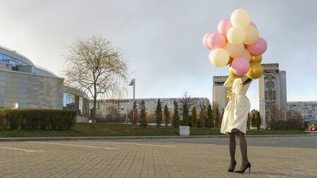 Happy woman with balloons on the background of the cityscape. Celebration on nature outdoors.の写真素材
