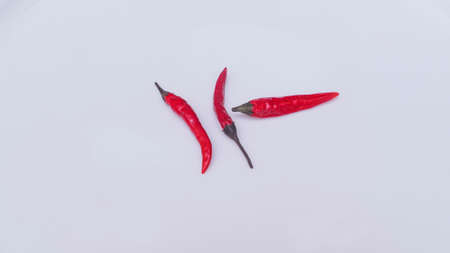 Three bright red chili peppers on white background. Space for text.の写真素材