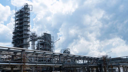 Distillation tower or column on blue sky with clouds background. Oil refinery plant. Refining...
