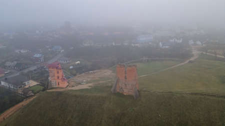 Aerial view of ruins of Tower Shchitovka and Mindovg Castle in Novogrudok, Belarus. Foggy landscape.
