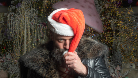 Styling Santa hipster with a long beard posing on the Christmas wooden background.の写真素材