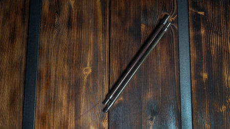Two modern carbon hookah mouth tubes on wooden table background.の写真素材