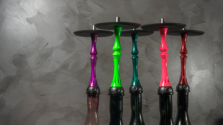 Several new modern multi-colored Hookah water pipes on gray background.