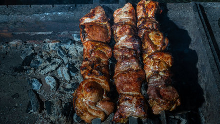 Kebabs threaded on skewers roasted on the grill on the dark background. Defocused smoke on the foreground.の写真素材