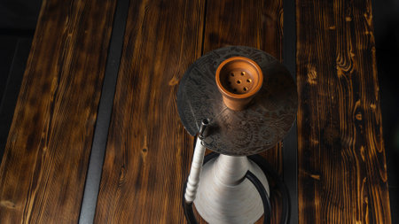 Top view of the modern white artificial stone marble hookah on the wooden table. Space for text.