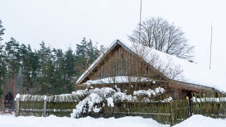 Winter snow covered village house, fence and trees. Nice old village house in the middle of beautiful winter with lots of white snow and trees.の写真素材