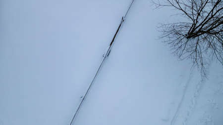 Aerial view of a wooden fence in a snow covered field. Snow covered wooden fence line that borders a...
