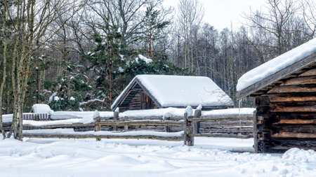 Winter snow covered village house, fence and trees. Nice old village house in the middle of...