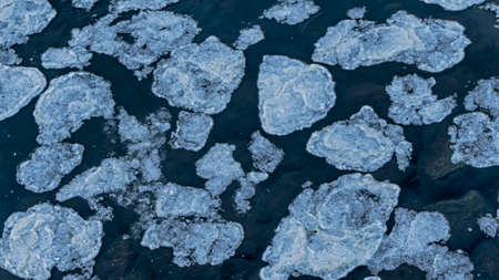 Fast ice. Ice floes background of winter river. Breaking and melting ice.