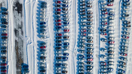 View from above at a large warehouse of new cars. Aerial view new cars lined up in the car warehouse for sale. Wintertime.の写真素材