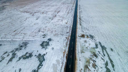 Top view from the air on the winter road in the field on which cars are going. Space for text. Travel concept.の写真素材