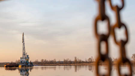 Dredger is working to deepen the fairway on the river. Cleaning and deepening by a dredger on the...