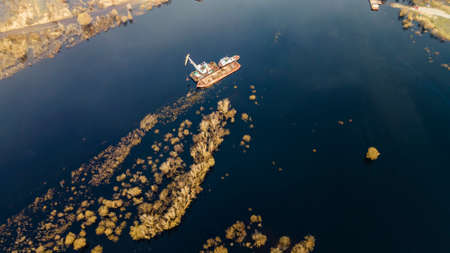 Dredger is working to deepen the fairway on the river. Cleaning and deepening by a dredger on the...
